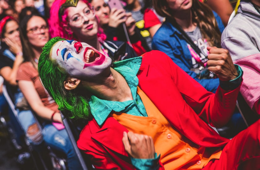 Na imagem, um cosplay do Coringa/Joker está em meio ao público da CCXP de cabelo verde e terno laranja. Teremos o Coringa de volta na CCXP22?